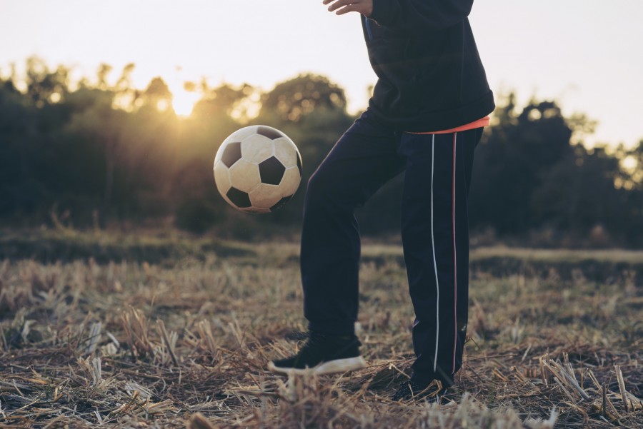 Quels sont les bénéfices spécifiques de l'échauffement avec ballon pour les footballeurs ?